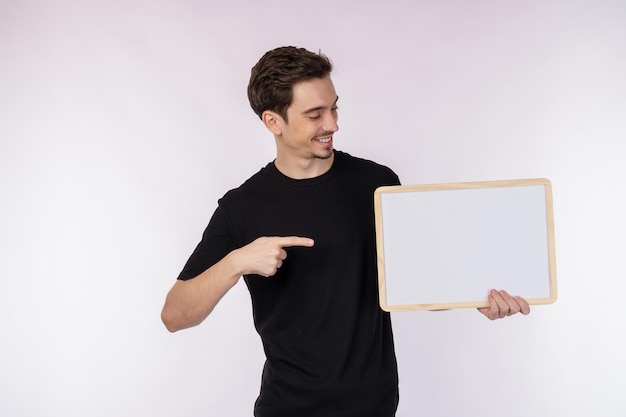 Free photo portrait of happy man showing blank signboard on isolated white background