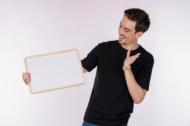 Free photo portrait of happy man showing blank signboard on isolated white background