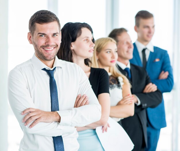 Portrait of a happy manager with his employees standing in a row