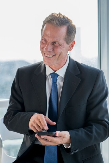 Portrait of a happy mature businessman holding mobile phone