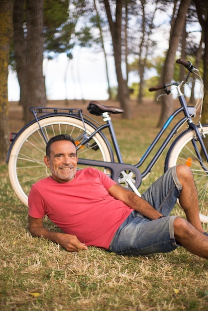 Free photo portrait of happy mature man resting at bike