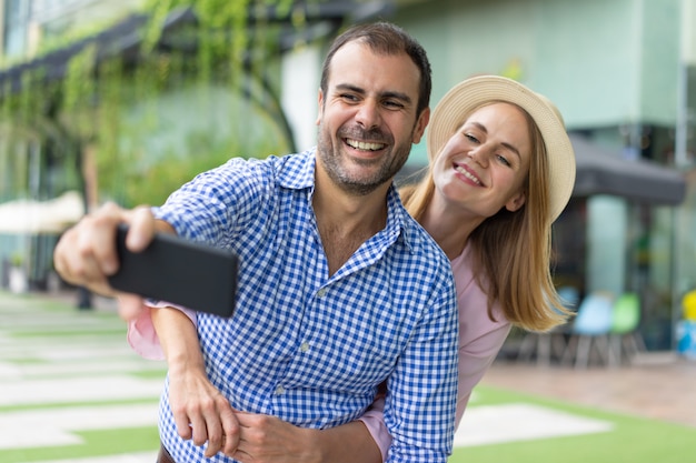 Free Photo portrait of happy mid adult couple taking picture with mobile phone.