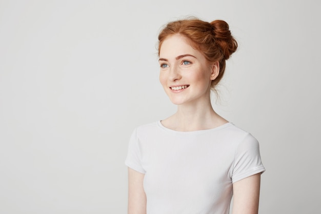 Portrait of happy redhead pretty girl with freckles smiling .