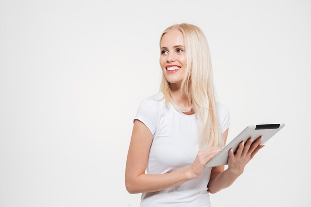 Portrait of a happy smiling blonde woman holding tablet computer