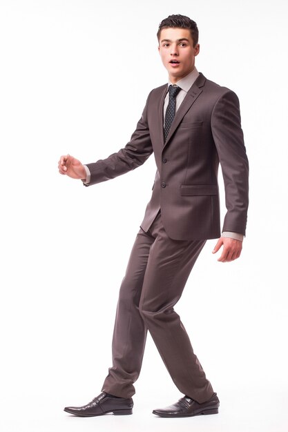 Portrait of happy smiling young businessman in brown suit isolated on white wall