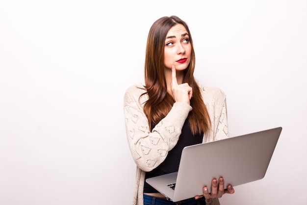 Portrait of happy surprised woman standing with laptop on gray