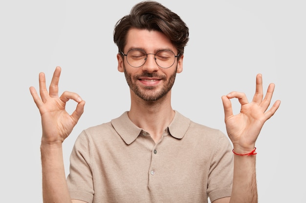 Free Photo portrait of happy unshaven young male hipster makes ok sign