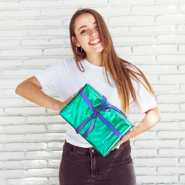 Free photo portrait of a happy woman holding green gift box