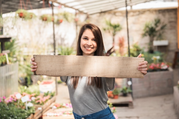 Portrait of a happy woman holding wooden plank