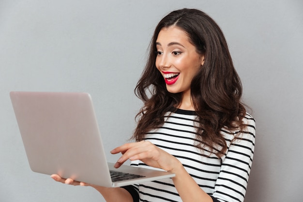 Portrait of a happy woman using laptop computer