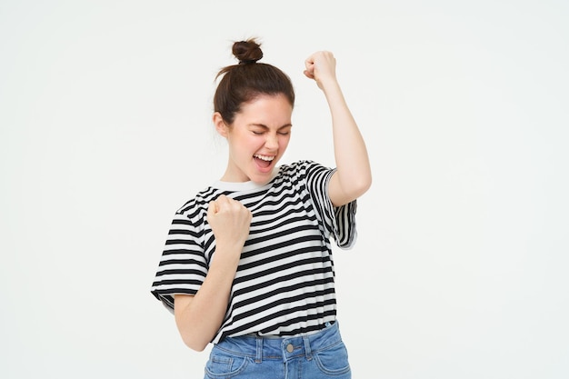 Free Photo portrait of happy woman winning celebrating victory rooting for team triumphing standing over white