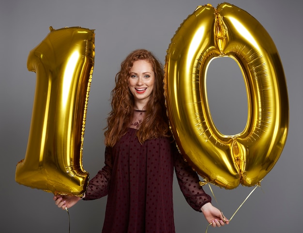 Free photo portrait of happy woman with balloons in ten shape