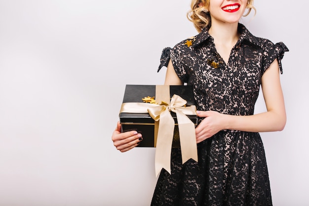 Portrait happy woman with black gift box in hand, red lips, black dress, smile.