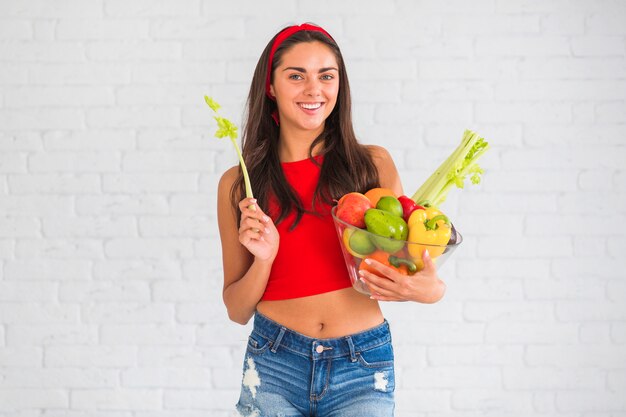 Portrait of a happy woman with healthy food in the bowl