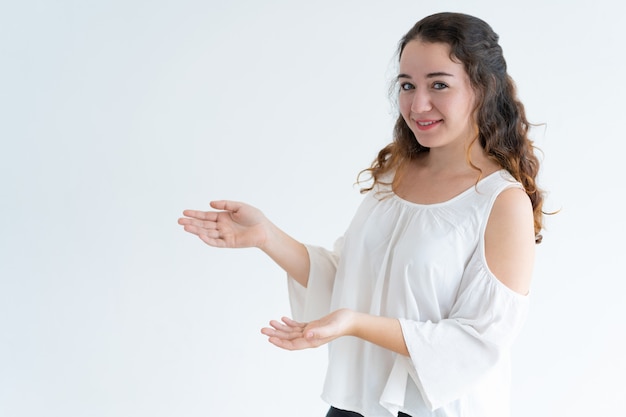 Portrait of happy young Caucasian woman advertising product