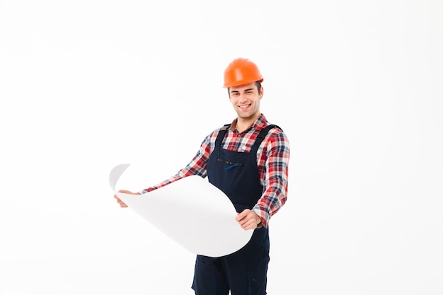 Portrait of a happy young male builder holding paper draft