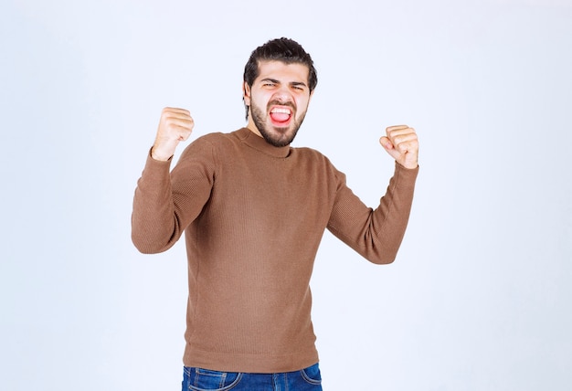 Portrait of a happy young man model in successful pose.