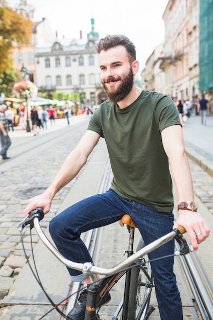 Portrait of a happy young man with bicycle