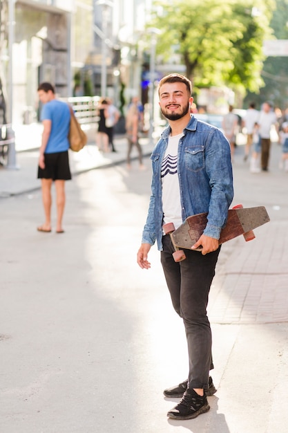 Portrait of a happy young man with skateboard