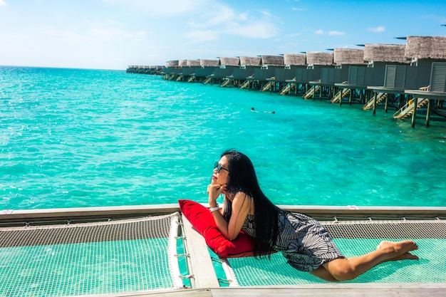 Portrait of happy young woman at beautiful water villa at Maldives island. Travel and Vacation. Outdoor shot