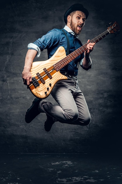 Free photo portrait of the hipster bass player dressed in cylinder hat.