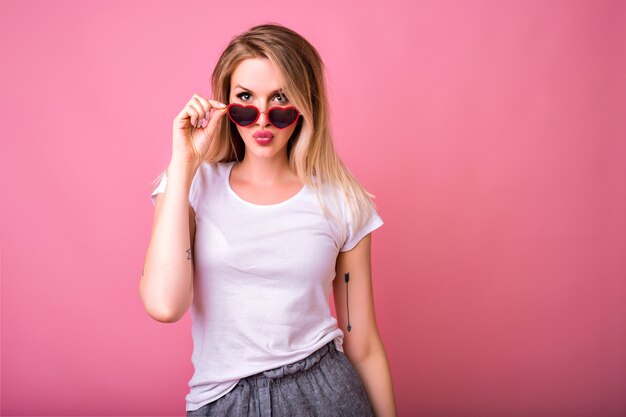 Portrait of hipster blonde woman posing on pink