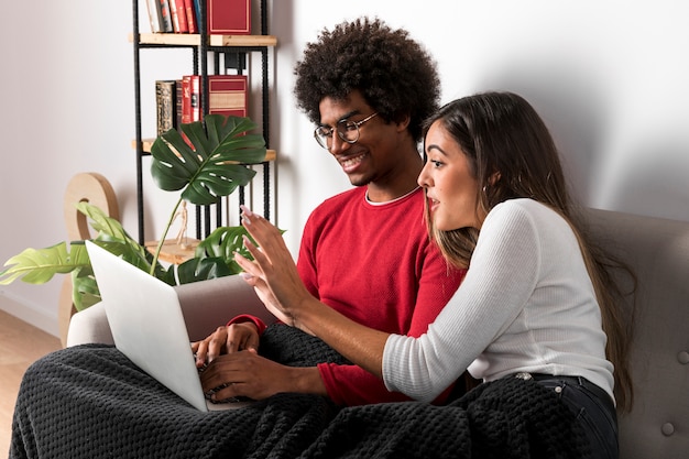 Portrait of interracial couple using laptop together