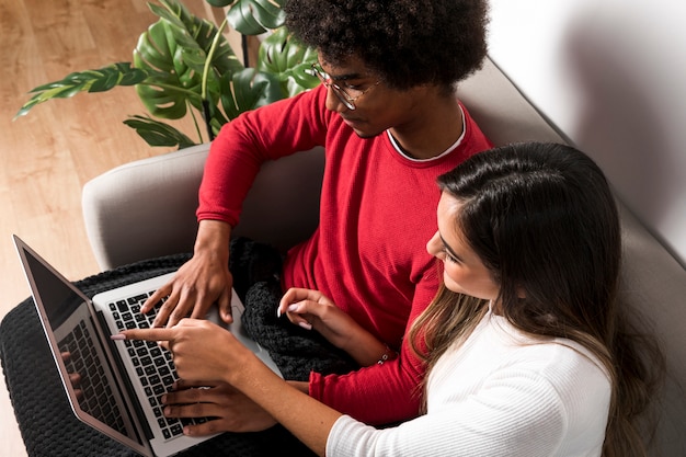 Portrait of interracial couple using laptop together