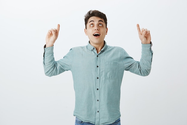 Portrait of intrigued handsome young man in casual shirt