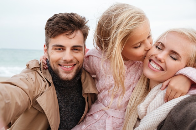 Portrait of a joyful family with a little daughter playing