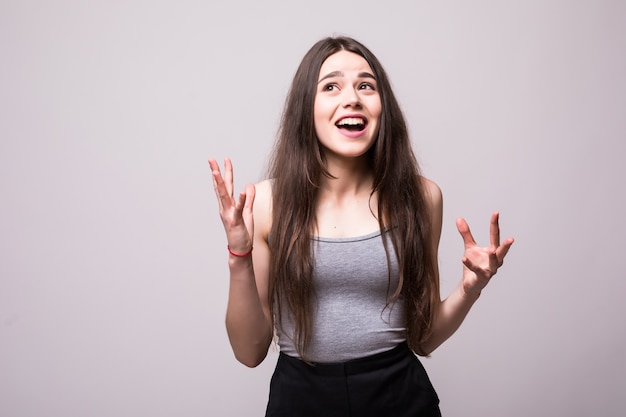 Portrait of a joyful happy teenage girl dressed in denim jacket celebrating success while dancing isolated