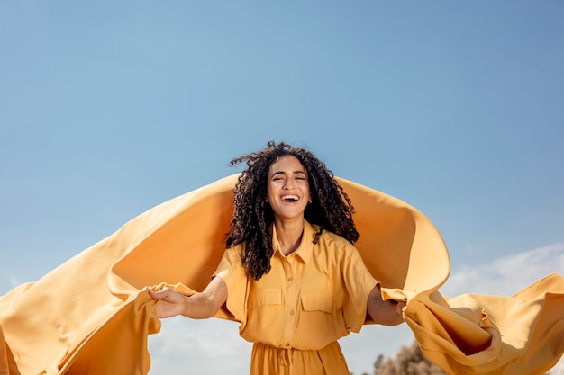 Free photo portrait of joyful woman with yellow cloth in nature