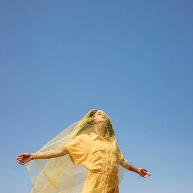 Portrait of joyful woman with yellow cloth in nature