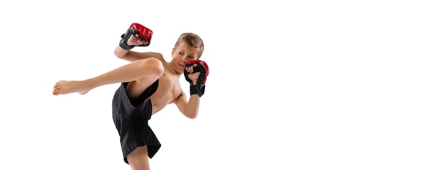 Free photo portrait of little boy kid in uniform training practicing thai boxing on white studio background