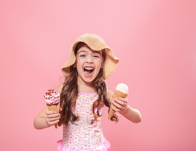 Portrait of a little cheerful girl with ice cream on a colored background