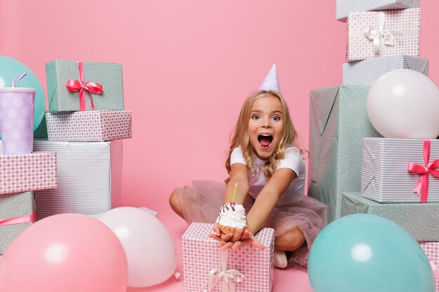 Portrait of a little girl in a birthday hat celebrating