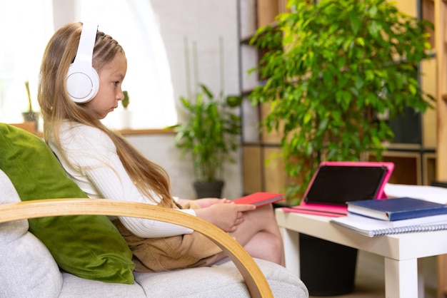 Free Photo portrait of little girl child studying at home looking on laptop working with teacher online education