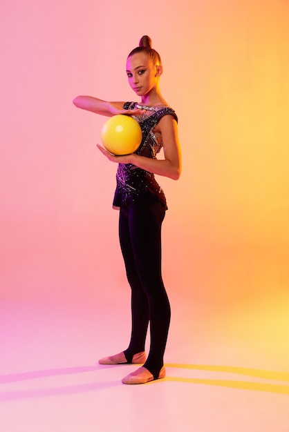 Free photo portrait of little girl, rhythmic gymnastics artist training isolated on colored