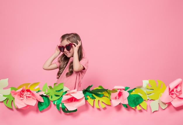 Free photo portrait of a little girl with sunglasses on a pink background