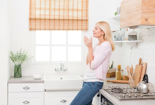 Free photo portrait of lovely senior woman enjoying coffee at home