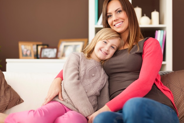 Portrait of loving mother with daughter on sofa