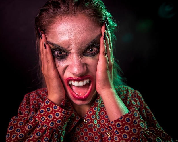 Free photo portrait of a make-up clown horror character screaming