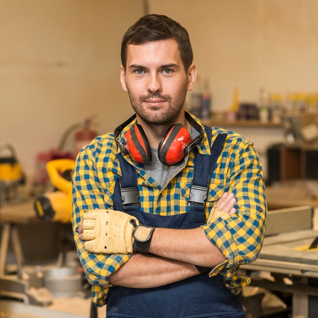 Portrait of a male carpenter standing with his arms crossed