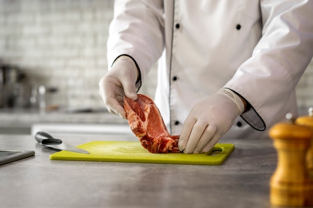 Free photo portrait of male chef in the kitchen preparing meat