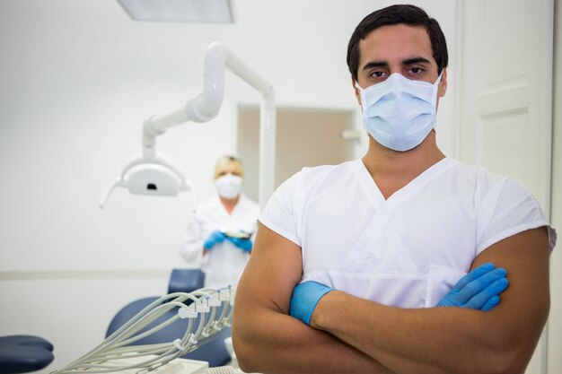 Portrait of male dentist standing with arms crossed