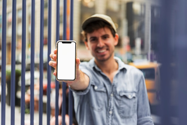 Portrait male holding smartphone and looking at camera