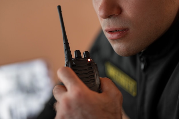 Free photo portrait of male security guard with radio station and camera screens