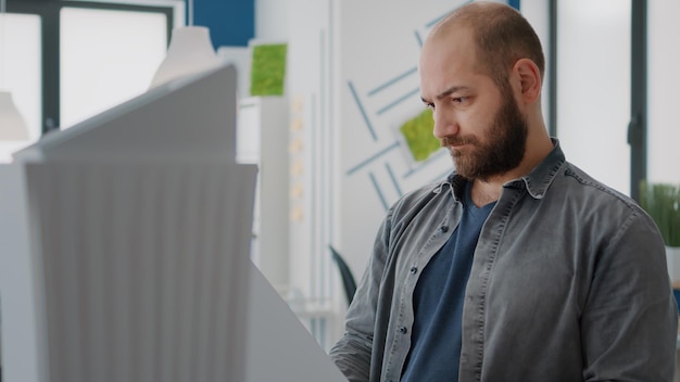 Free photo portrait of man architect analyzing building model to design urban construction in office