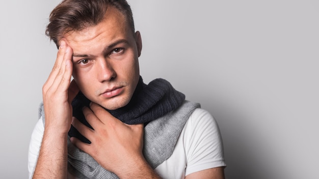 Free photo portrait of man having headache against gray background