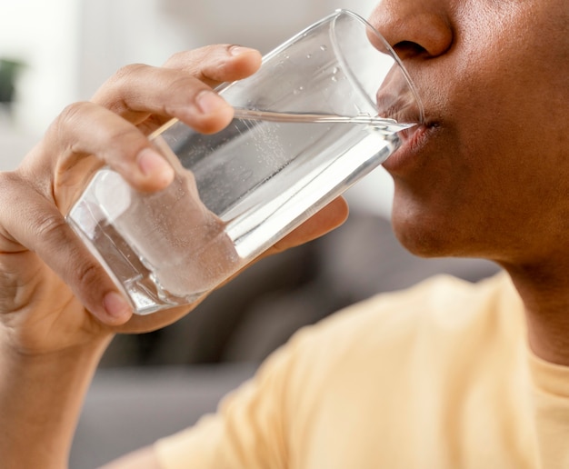 Portrait man at home drinking glass of water